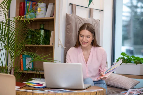 Designer girl working on a laptop with a color palette. — Stock Photo, Image