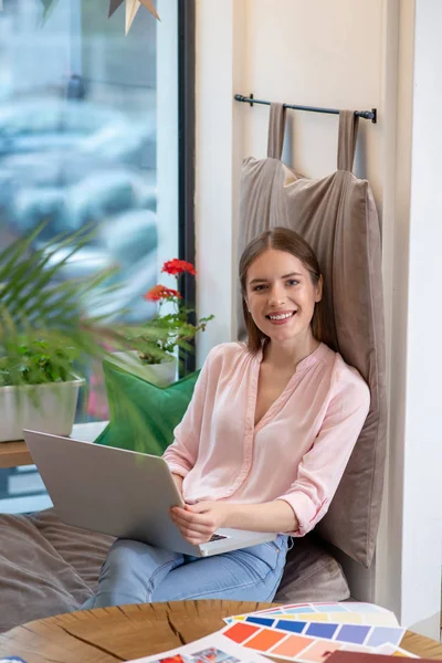 Smiling young designer working with her laptop — Stock Photo, Image