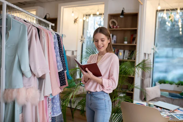 Joven diseñadora de moda poniendo sus ideas en el cuaderno — Foto de Stock