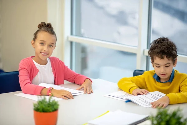 Boy and a girl preparing their homework together — Stock Photo, Image