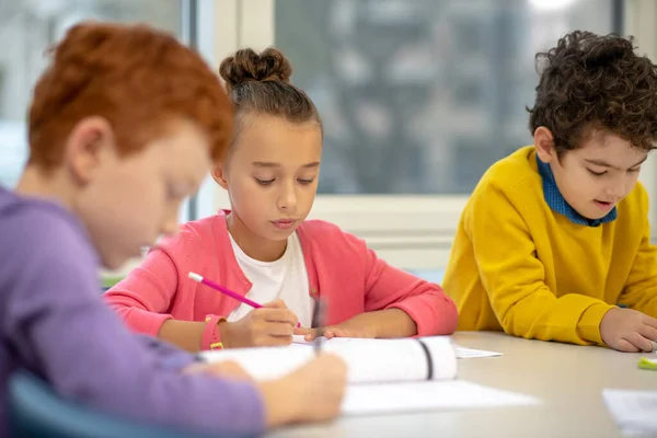 Focused school children working on their exercises — 스톡 사진