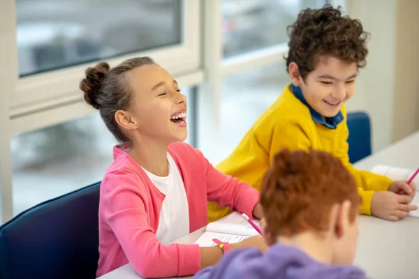 Vrolijk schoolmeisje lacht tijdens de les — Stockfoto