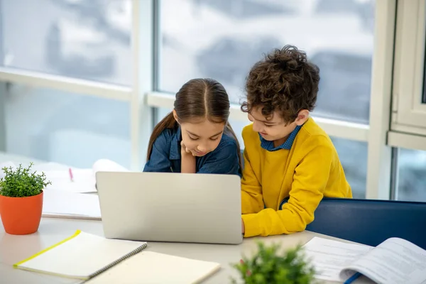 Niño ayudando a una chica en el uso de la computadora portátil — Foto de Stock