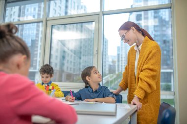 Öğretmen öğrencilerinin sonuçlarını kontrol ediyor.