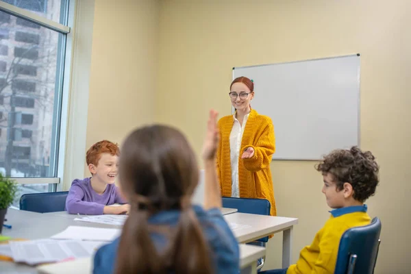 Profesora preguntando a sus alumnos durante la lección —  Fotos de Stock