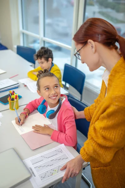 Läraren prisar en skolflicka för hennes goda resultat — Stockfoto