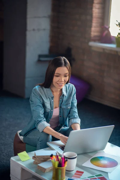 Agradable mujer joven positiva escribiendo en el teclado — Foto de Stock