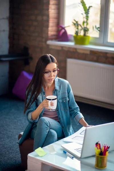 Serious smart woman holding a cup with tea