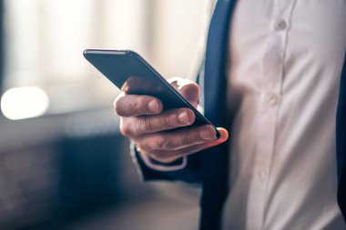 Close up picture of mans hand holding a smartphone