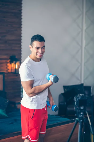 Forte uomo dai capelli scuri in pantaloncini rossi sorridente bene — Foto Stock