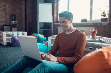 Neşeli, yakışıklı, serbest çalışan, evde çalışırken kendini iyi hisseden.