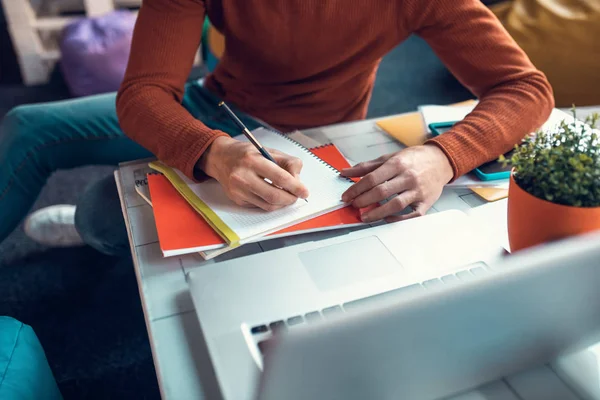 Student schreibt während der Prüfungsvorbereitung in sein Notizbuch — Stockfoto