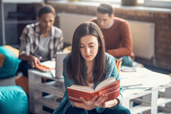 Dark-haired student feeling concentrated while studying Chinese