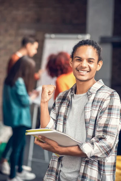 Cheerful student feeling happy while studying with friends