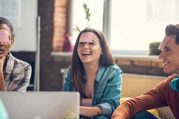 Vacker student ler medan du spelar ordspel med vänner — Stockfoto