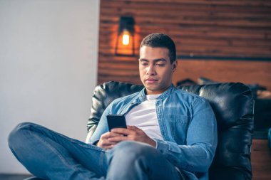 Evde akıllı telefona bakan tatlı bir adam..