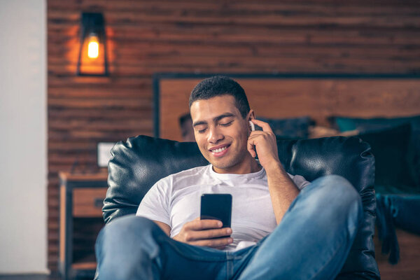 Парень в наушниках со смартфоном в руке
.