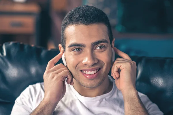 Όμορφος χαμογελαστός τύπος με άσπρα ασύρματα ακουστικά. — Φωτογραφία Αρχείου