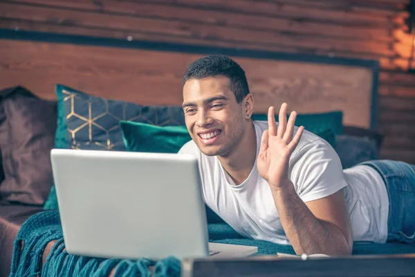 Cheerful guy greeting online in front of laptop screen. — 스톡 사진