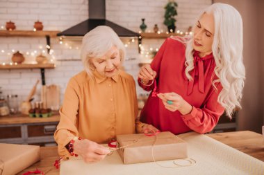Parlak elbiseli iki son sınıf güzeli hediye açıyor.