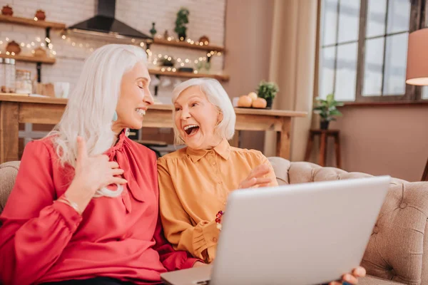 Twee aangenaam uitziende, grijze vrouwen die luid lachen. — Stockfoto