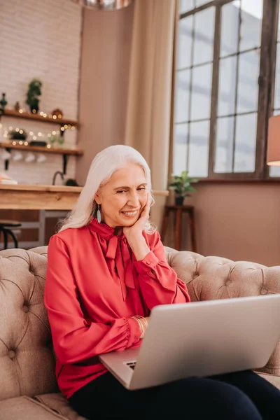 Long-haired beautiful lady in red holding a laptop — Stock Photo, Image