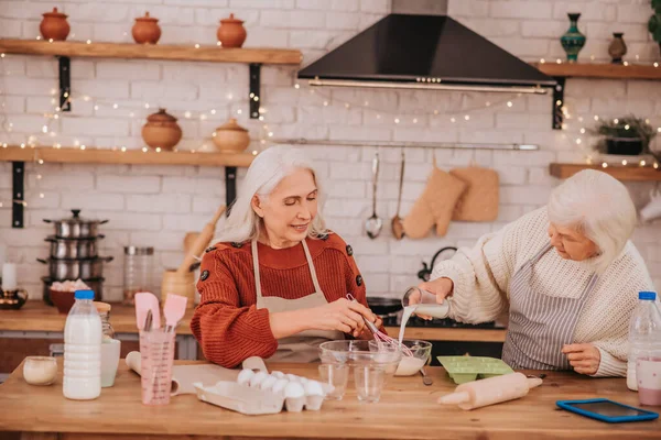 Két idős nő elfoglaltnak tűnik a konyhában. — Stock Fotó