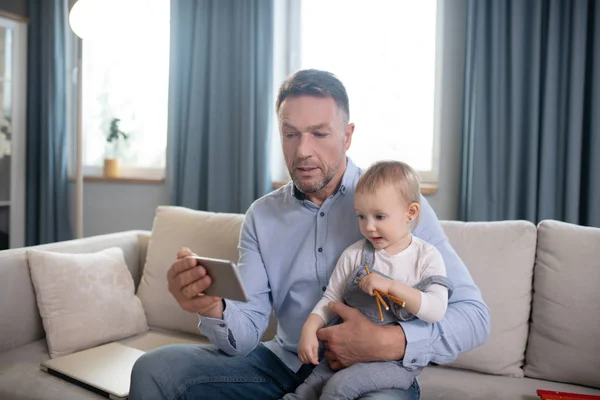 Starší otec a jeho malá dcera spolu sledují video — Stock fotografie