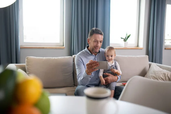 Reifer Vater zeigt seinem Kind etwas auf dem Tablet — Stockfoto