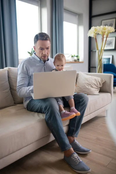 Ώριμος πατέρας εργάζεται για το laptop του και φαίνεται σοβαρή — Φωτογραφία Αρχείου