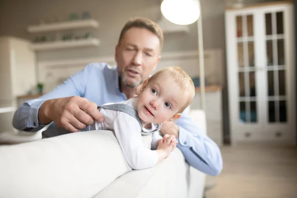 Dojrzały ojciec wygląda zadowolony spędzając czas w domu ze swoim dzieckiem — Zdjęcie stockowe