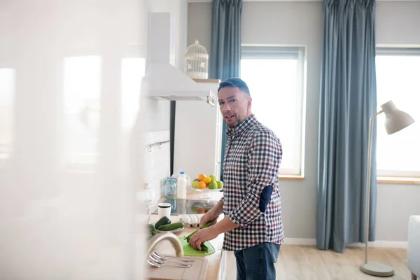 Hombre con camisa a cuadros cocinando en la cocina — Foto de Stock