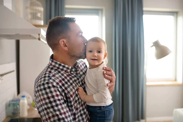 Father in a checkered shirt kissing his baby daughter — 스톡 사진