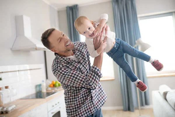 Padre con camisa a cuadros jugando con su hija bebé —  Fotos de Stock