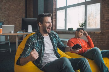 Neşeli genç adam video oyunu kazanıyor.