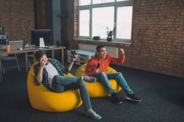 Evde video oyunu oynayan mutlu gençler.