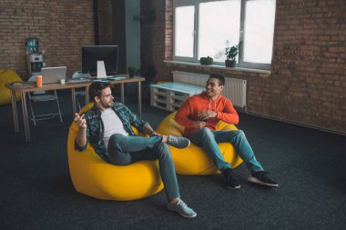 Memleketteki puf minderlerde oturan neşeli pozitif arkadaşlar.