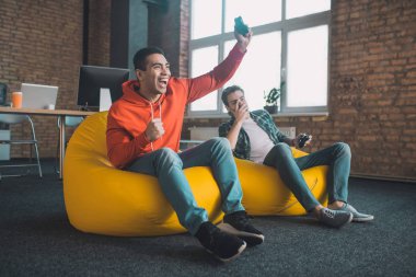 Neşeli adam oyun konsolunu deliğe sokuyor