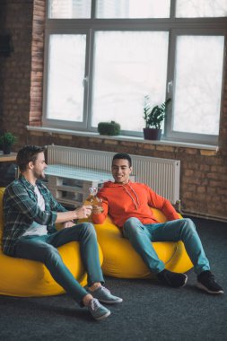 Puf minderlerde oturan neşeli arkadaşlar.