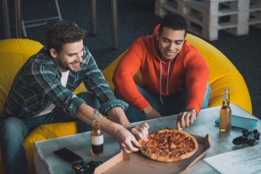 Yakışıklı aç adamlar pizza alıyor.