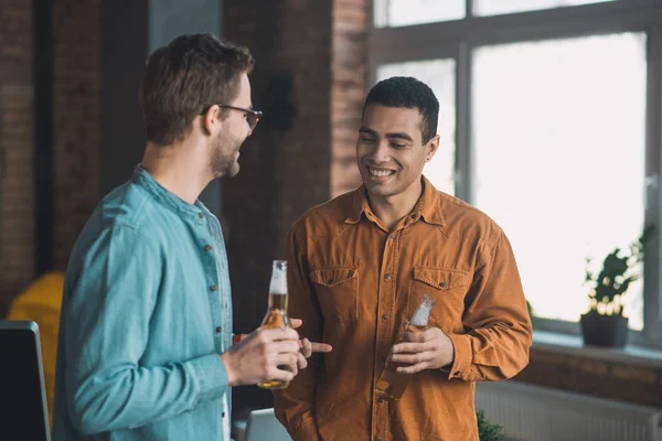 Jovens amigos felizes positivos bebendo cervejas juntos — Fotografia de Stock