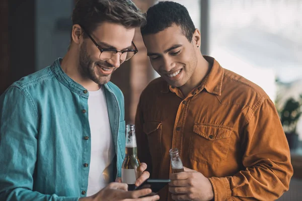 積極的な陽気な男性が一緒にスマートフォンの画面を見て — ストック写真