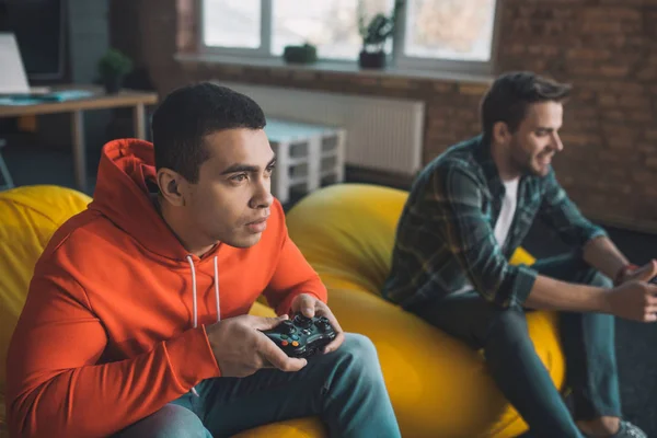 Beaux jeunes hommes jouant station de jeu à la maison — Photo