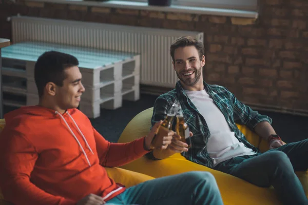 Amigos masculinos alegres positivos animando con la botella de cervezas — Foto de Stock