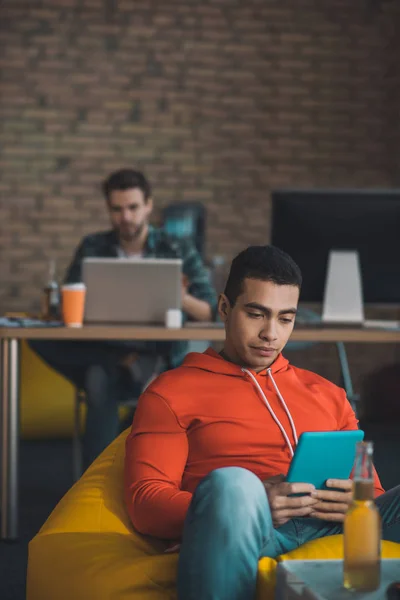 Joven serio mirando la pantalla de su tableta — Foto de Stock