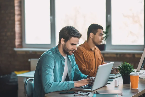 Bonito homem inteligente concentrando-se em seu trabalho — Fotografia de Stock