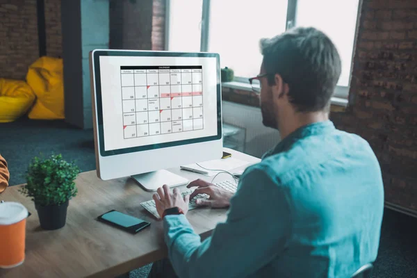 Bom homem inteligente olhando para o calendário — Fotografia de Stock