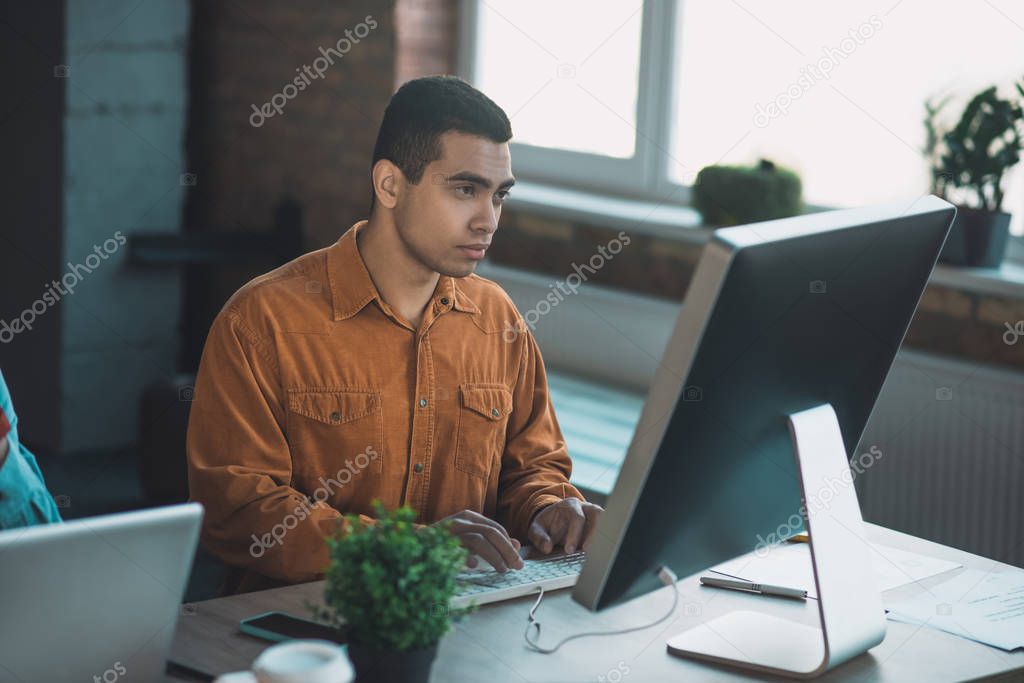 Smart good looking man typing the text