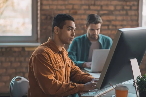 Bonito homem inteligente olhando para a tela do computador — Fotografia de Stock