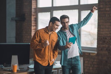 Yakışıklı, mutlu genç adam elini kaldırıyor.